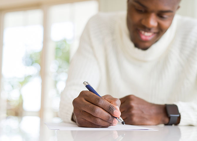 man writing on paper