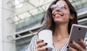 woman carrying phone and coffee
