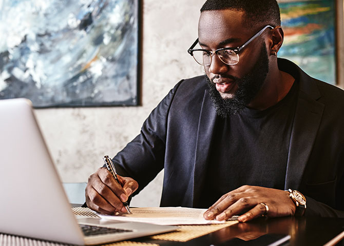 man writing on paper