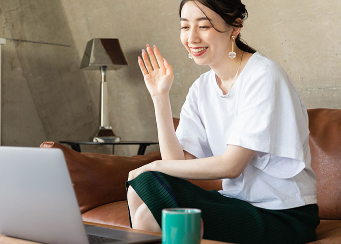 woman waving at laptop screen