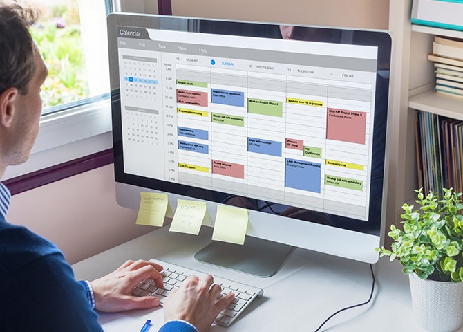 Healthcare professional using interview scheduling software on desktop to manage candidate interviews efficiently.