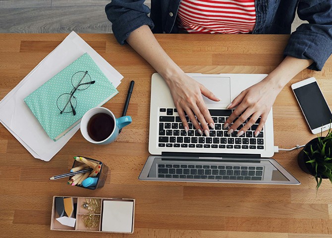 Person working on a laptop at a desk, symbolizing how on demand video interviews help recruiters streamline hiring.
